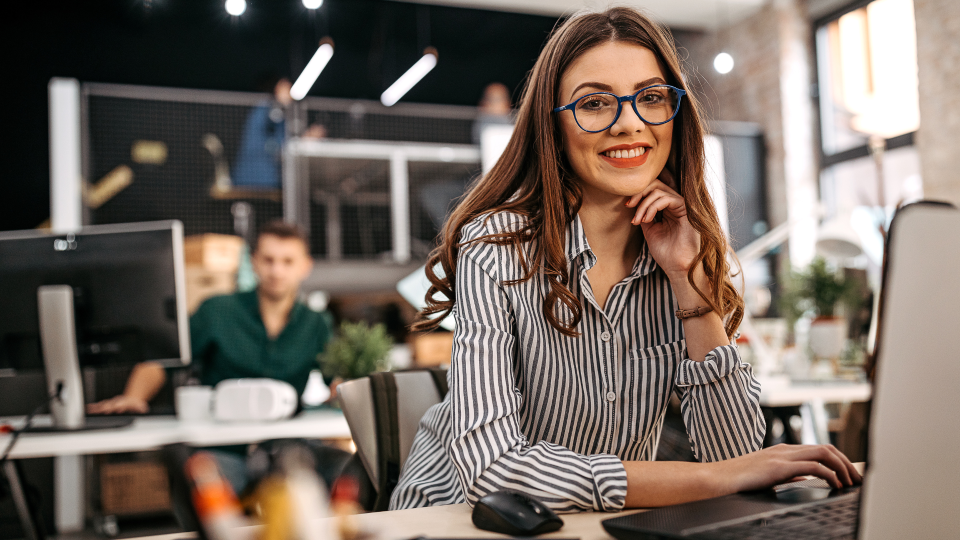 Junge Geschäftsfrau lächelt freundlich in die Kamera