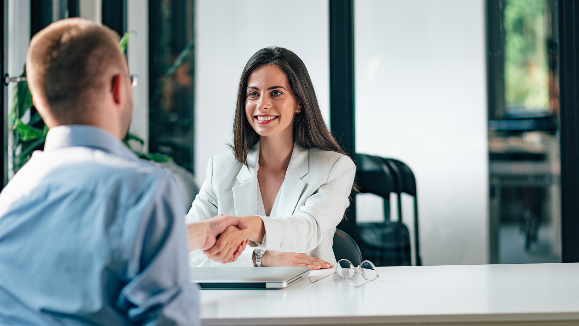 Freundliche Geschäftsfrau begrüßt sitzend Arbeitskollegen